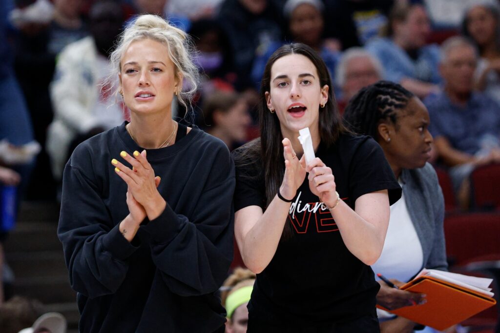 Indiana Fever guard Sophie Cunningham and guard Caitlin Clark react from the bench