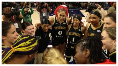 Washington Mystics players celebrate in a huddle at midcourt after their game against the Minnesota Lynx