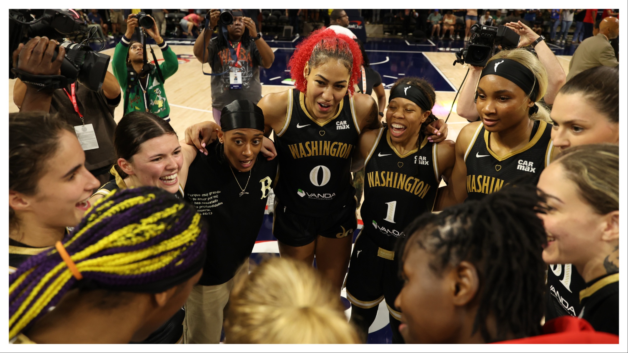 Washington Mystics players celebrate in a huddle at midcourt after their game against the Minnesota Lynx
