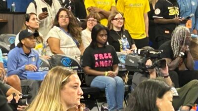 Cameras Caught Angel Reese's Fan With 'Free Angel' Shirt Moments Before Security Escorts Her To Courtside Seats