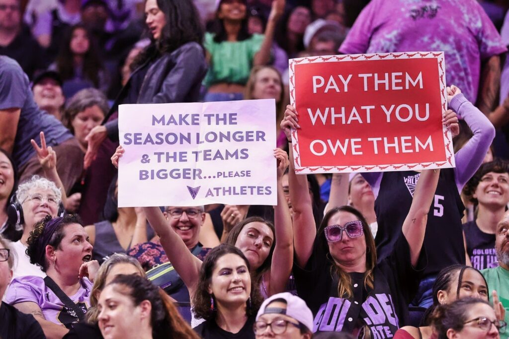 Golden State Valkyries Fans Hold Signs to &ldquo;Make the Season Long and the Teams Bigger&rdquo; and &ldquo;Pay Them What You Owe Them&rdquo; During the Fourth Quarter Against the Washington Mystics at Chase Center
